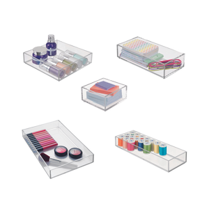 Doorzichtige opbergdozen met cosmetica, pennen, garen en elastiekjes in de kamer.