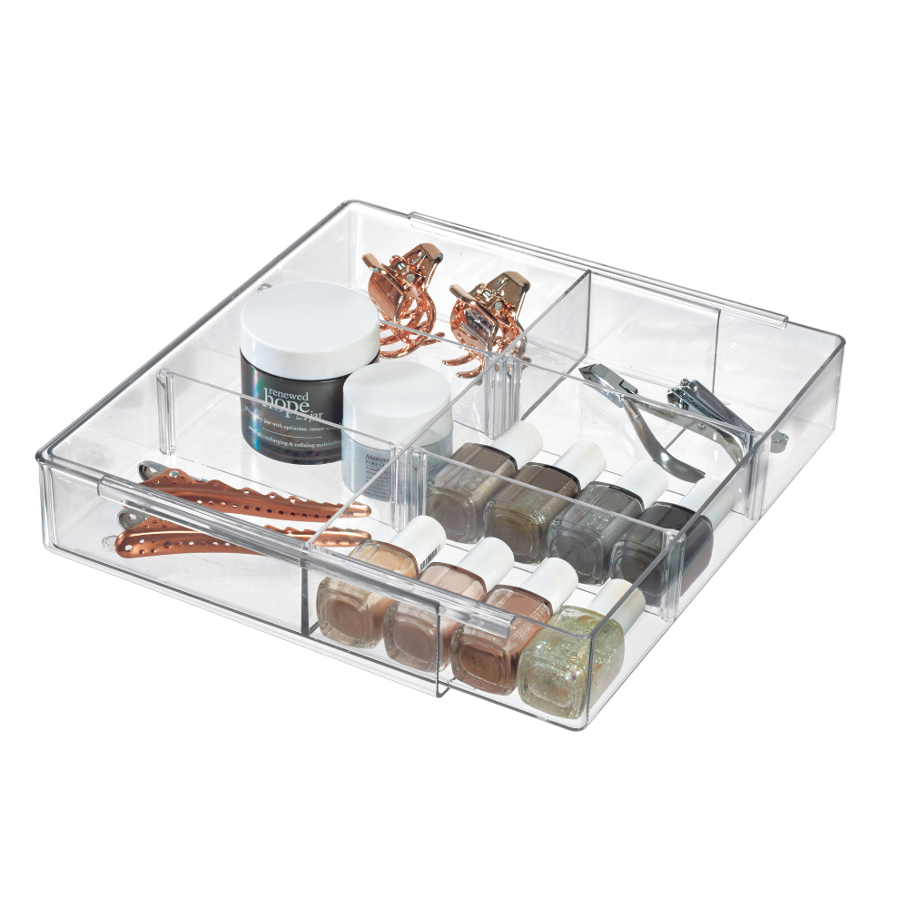 De iDesign HOME EDIT - lade-organizer TRANSPARANT - uitschuifbaar houdt nagellak, twee potjes, roségouden haarspeldjes, een nagelknipper en haarnetjes netjes geordend in aparte vakjes.
