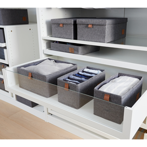 Twee Love it Store it PREMIUM-opbergbakken met 6 vakken (smal, grijs) staan op een witte plank met glazen wanden in een kledingkast-opbergsysteem, elk netjes gevuld met kleding. Op de planken erboven zie je nog meer opbergvakken.