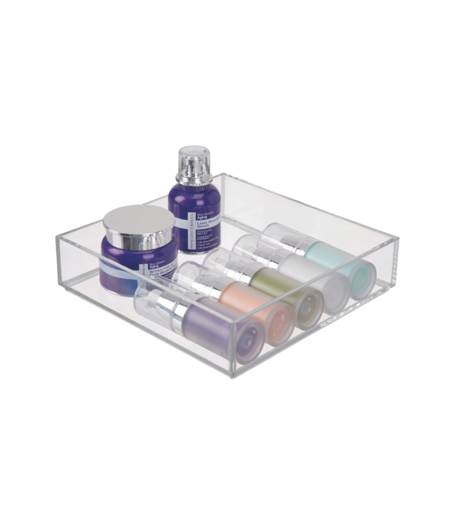 Een doorzichtige bak met kleurrijke cosmeticaflesjes en -potjes, op een witte ondergrond.