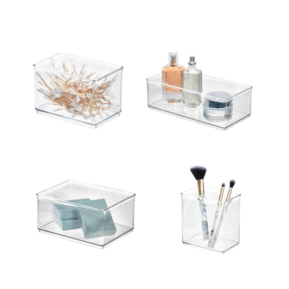 Vier doorzichtige plastic doosjes met wattenstaafjes, parfum, stukjes zeep en make-upkwasten.