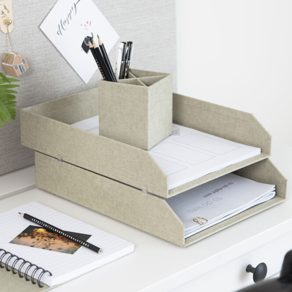 Een stijlvolle bureau-inrichting met twee beige Bigso HAKAN-documentenhouders (set van 2 stuks) – linnen canvas bakjes met documenten, een bijpassende pennenhouder met potloden, een notitieboekje, een pen en een plantje voor een opgeruimde look.
