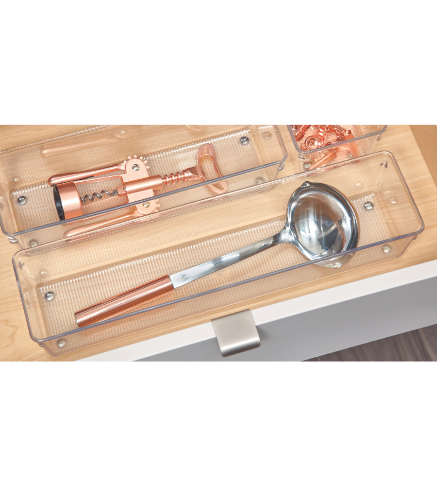 Een zilveren pollepel met koperen handvat en een koperen kurkentrekker zijn netjes opgeborgen in doorzichtige bakjes uit de iDesign-lade-organizer-set LINUS - HOOG (5-delig) in een lichte houten lade.