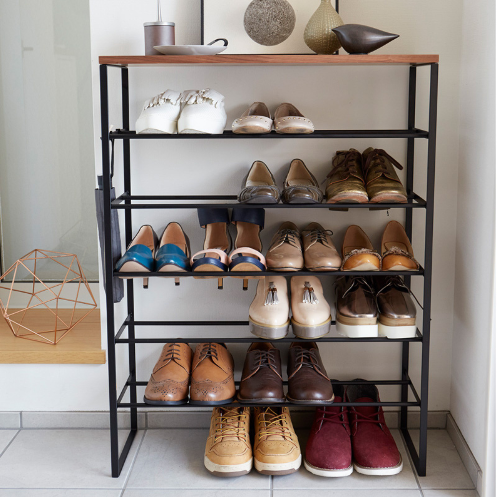 Een schoenenrek met verschillende schoenen, versierd met spulletjes erop.