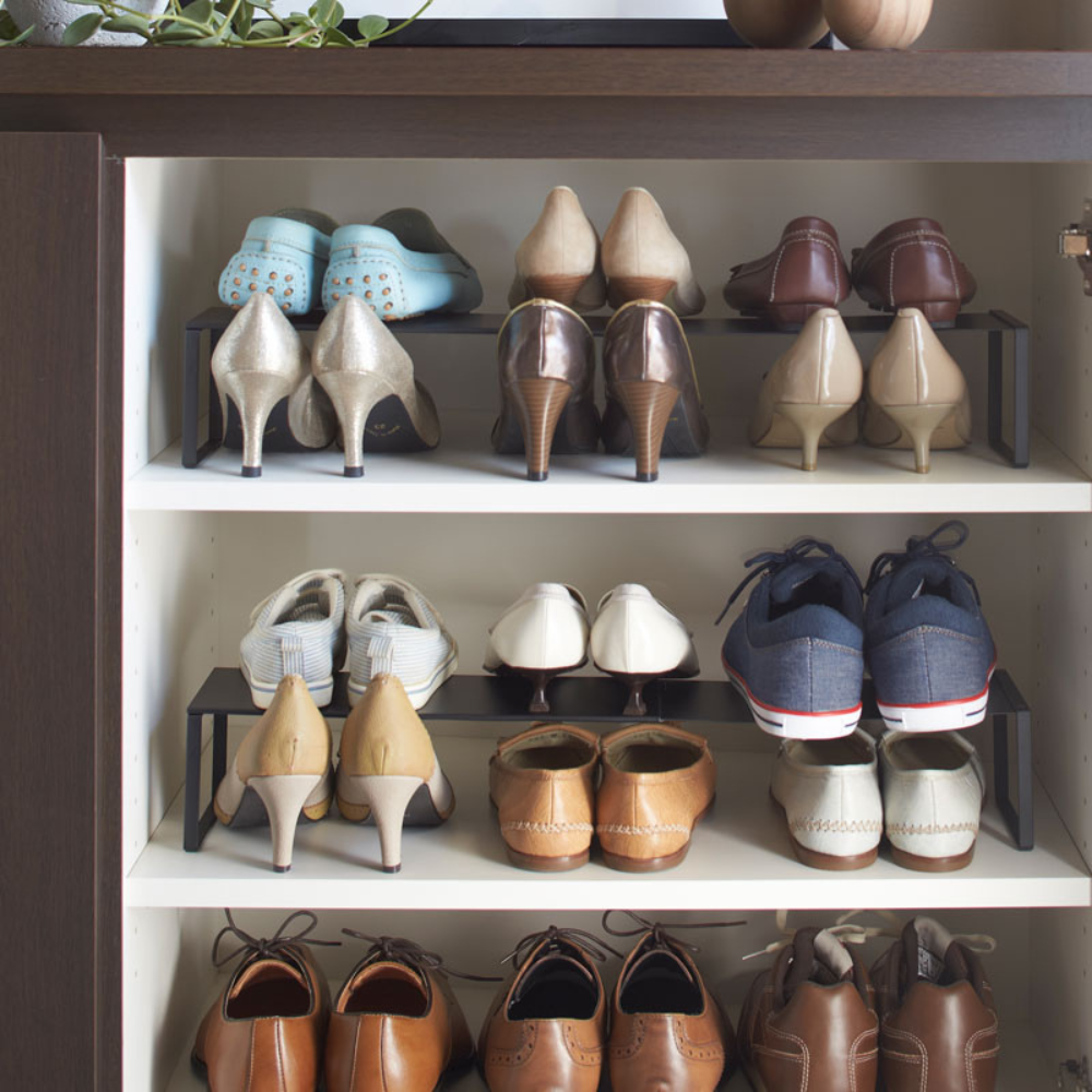 De YAMAZAKI FRAME uitschuifbare schoenenkast - zwart biedt ruimte voor dames- en herenschoenen, sandalen en sneakers in drie vakken in een elegante zwarte kast voor extra opbergruimte.
