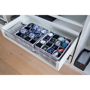 Op een witte plank staat een STAR Organizer met 16 vakken in grijs – set van 2 stuks van Love it Store it, met stoffen verdelers die sokken en ondergoed overzichtelijk sorteren. De houten bodem is eronder zichtbaar – perfect voor de kinderkamer.