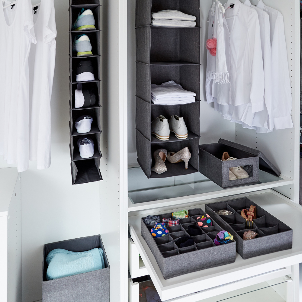 Een goed georganiseerde kledingkast met een schoenenrek, planken voor opgevouwen kleding, witte overhemden op hangers en een Love it Store it PREMIUM wasmand in grijs – met 8 vakken voor sokken, stropdassen en accessoires.