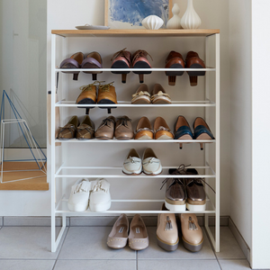 De YAMAZAKI TOWER houten schoenenrek in wit heeft vijf planken voor damesschoenen zoals ballerina’s, loafers en oxfords in neutrale kleuren. Het ruimtebesparende rek staat netjes in de lichte gang.