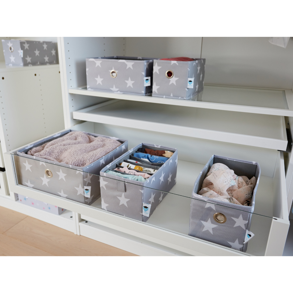 Twee sets Love it Store it STAR-opbergers met 6 vakken, smal, grijs (in totaal 4 vakken) met witte sterren en metalen ringgrepen, voor opgevouwen kleding of handdoeken, netjes gerangschikt op de planken in een witte kinderkast.