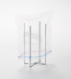 De YAMAZAKI TOWER multifunctionele keukenhouder - wit houdt een doorzichtig plastic zakje met ritssluiting open. Deze opvouwbare keukenhouder met vier poten maakt het werk makkelijker en wordt getoond tegen een eenvoudige witte achtergrond.