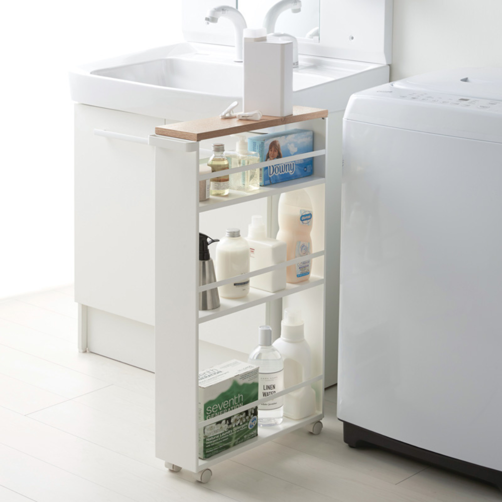 De TOWER-keukentrolley met handgreep in wit van YAMAZAKI is een slanke trolley met planken voor was- en schoonmaakmiddelen. Hij past ruimtebesparend tussen de wastafel en de wasmachine in de lichte, minimalistische wasruimte – en zorgt voor maximale opbergruimte.