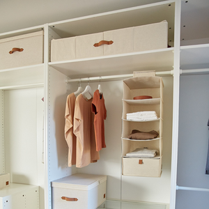 Open kledingkast met beige opbergboxen, drie perzikkleurige en beige overhemden op hangers en een hangende organizer. De PREMIUM opbergbox Beige – opbergruimte onder het bed van Love it Store it zorgt voor orde – perfect voor IKEA PAX-kledingkasten in neutrale tinten.