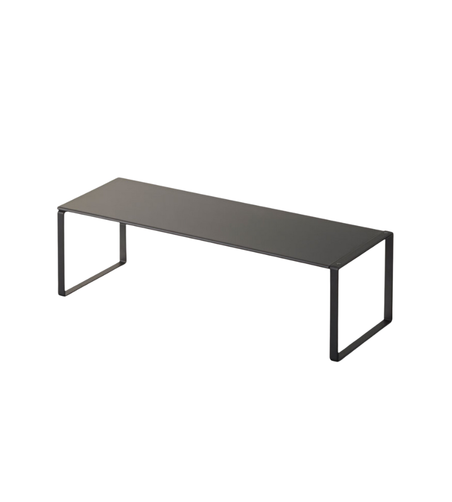 Het uitschuifbare FRAME schoenenrek van YAMAZAKI in zwart is een minimalistisch bankje met een platte zitting en open, rechthoekige poten aan beide uiteinden – ideaal voor het praktisch opbergen van schoenen tegen een witte achtergrond.