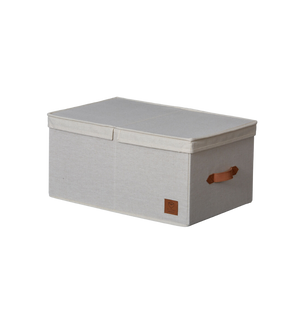 De PREMIUM opbergdoos met klapdeksel - Beige van Love it Store it is een rechthoekige opbergdoos met een opzetdeksel, een bruine handgreep aan de zijkant en een patch op de voorkant, afgebeeld tegen een eenvoudige witte achtergrond.