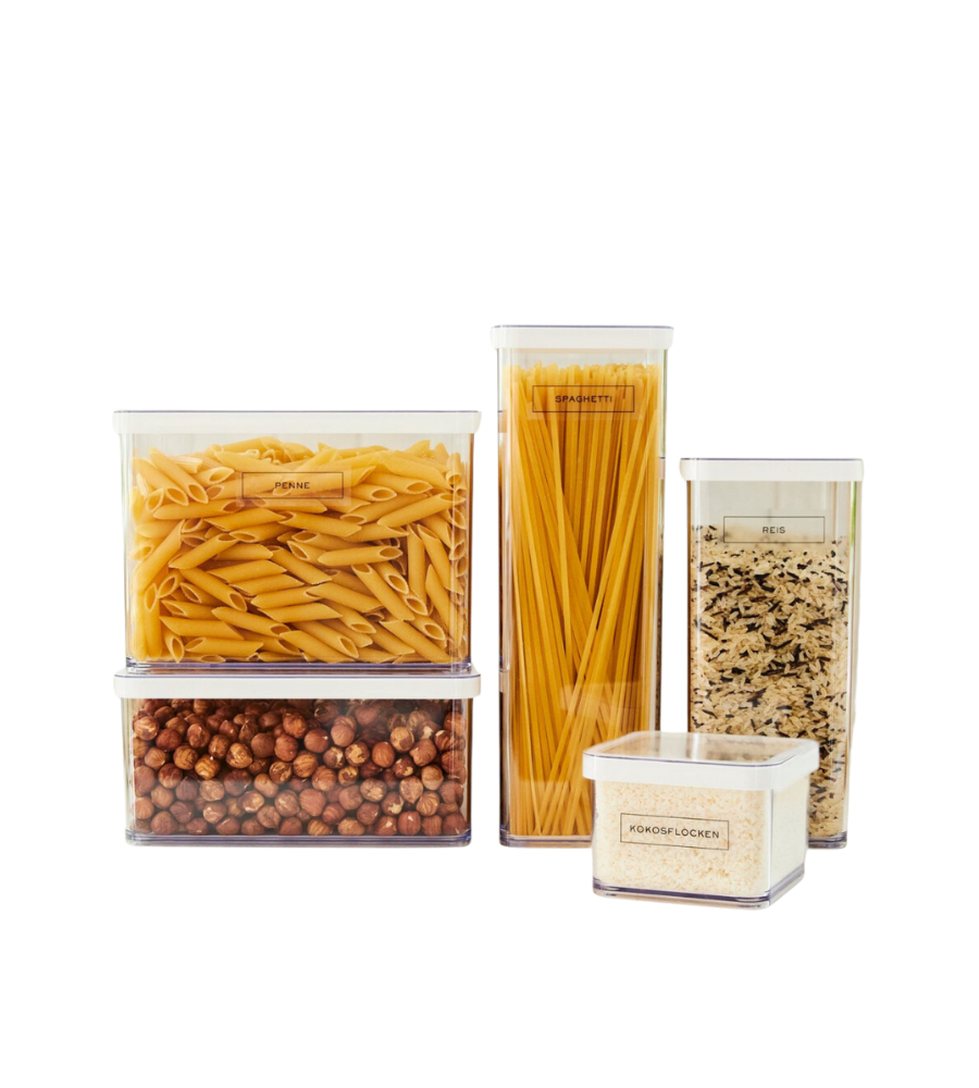Vijf doorzichtige, gelabelde bakjes met Rotho LOFT-stickers – voor een opgeruimde keuken: houd penne, spaghetti, rijst, kikkererwten en korte pasta geordend op een witte achtergrond.