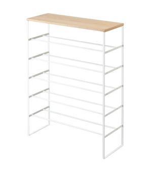 De TOWER schoenenrek van hout - wit van YAMAZAKI is een minimalistisch, ruimtebesparend schoenenrek met een lichte houten plank en een wit metalen frame met vijf planken tegen een witte achtergrond.