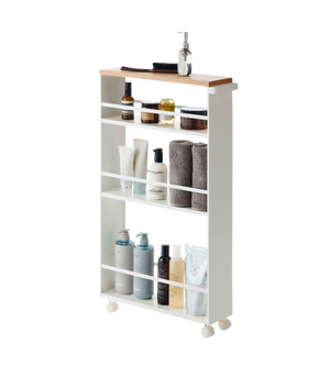Rek op wieltjes met verzorgingsproducten en handdoeken, drie niveaus met wit frame en houten plank.
