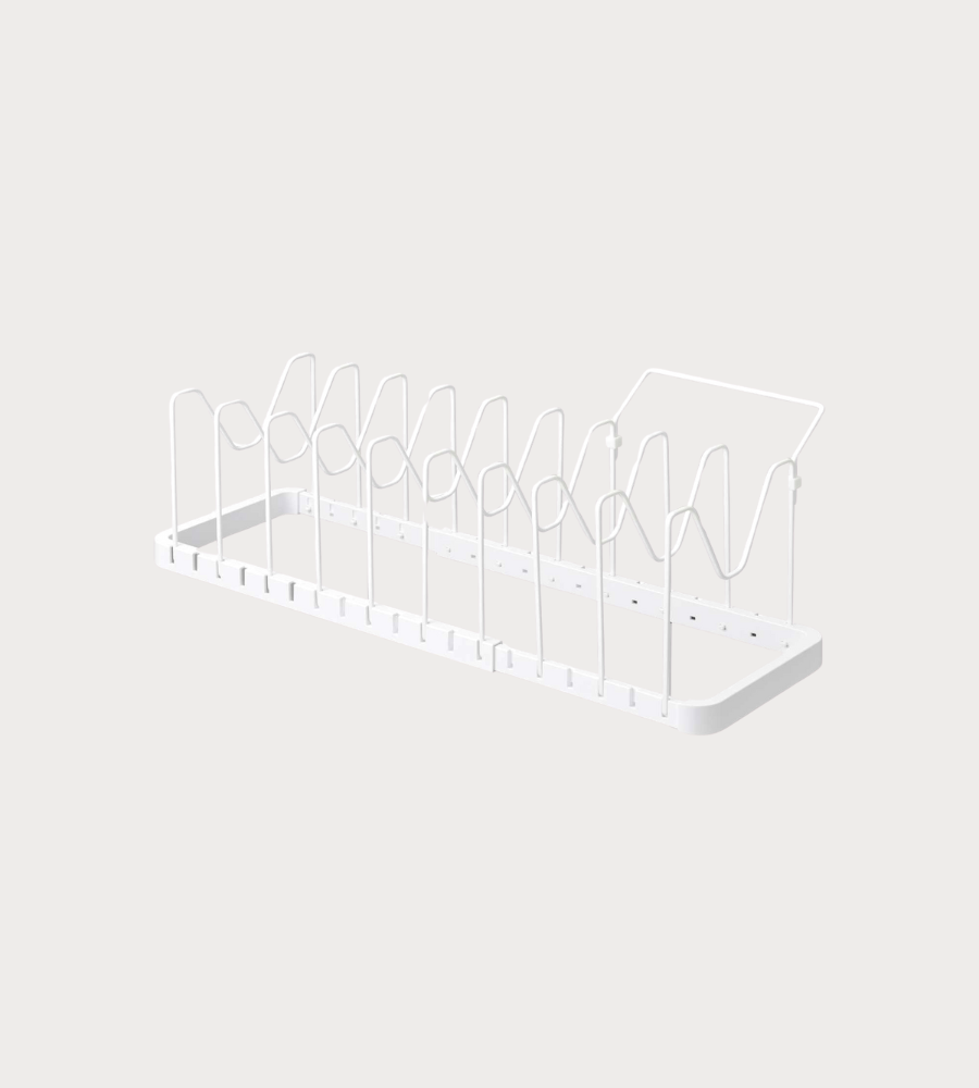 De YAMAZAKI TOWER uitschuifbare pannenrek in wit is een minimalistisch metalen pannenrek met verticale verdelers en een vlakke bodem – ideaal om borden en snijplanken op te bergen. De achtergrond is strak en licht.