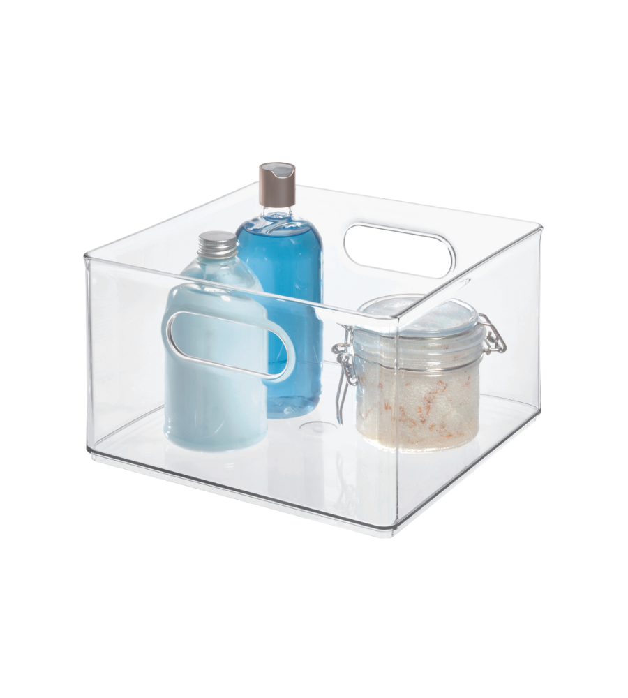 Een heldere, vierkante iDesign HOME EDIT opbergbak KLAR (25,4 x 25,4 x 15,2 cm) met handgreepuitsparingen bevat twee blauwe flessen en een pot met schuifdeksel, allemaal op een witte achtergrond.