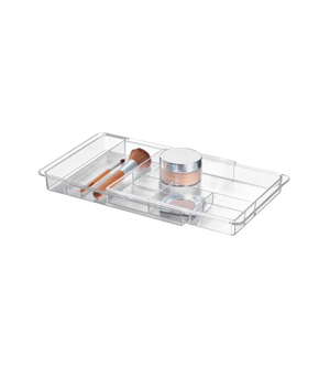 Doorzichtige opbergdoos met vakjes voor make-upproducten, op een witte achtergrond.