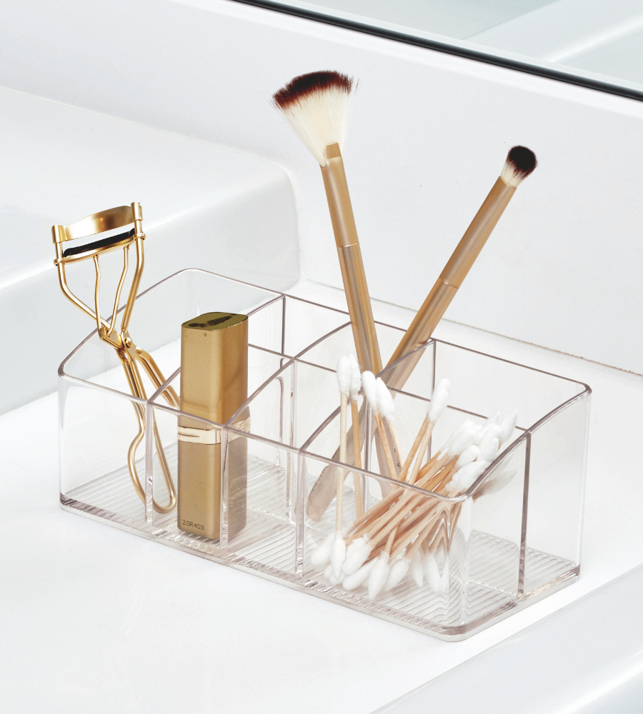 De iDesign LINUS MED - Multiorganizer KLAR zorgt voor orde op de badkamerwastafel en houdt make-upborstels, wattenstaafjes, wimperkruller en lippenstift binnen handbereik. Op de achtergrond zie je de wastafel en de spiegel.