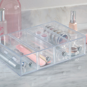 De iDesign DRAWER ladetoren KLAR met 4 vakken – smal zorgt met zijn stapelbare acrylladen voor een nette opbergplaats voor cosmetica zoals nagelvijlen, lippenstift en oogschaduw op het marmeren werkblad.