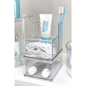 Opbergsysteem met tandpasta, tandenborstels en flosstaafjes in de badkamer, tube „WONDERMINT“ in het zicht.