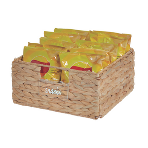 De iDesign HOME EDIT etikettenhouder KLAR (set van 3 stuks) is een rechthoekig gevlochten mandje met het opschrift "Snacks", waarin meerdere gele snackzakjes overzichtelijk zijn gerangschikt. De natuurlijke vezel-look geeft hem een gestructureerde uitstraling.