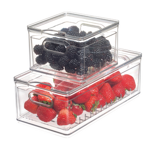 Twee iDesign HOME EDIT vershoudbakjes KLAR Berry Bin klein van BPA-vrij kunststof met handvatten aan de zijkant – in het ene zitten bramen bovenin, in het grotere aardbeien onderin. Beide staan op een witte achtergrond.